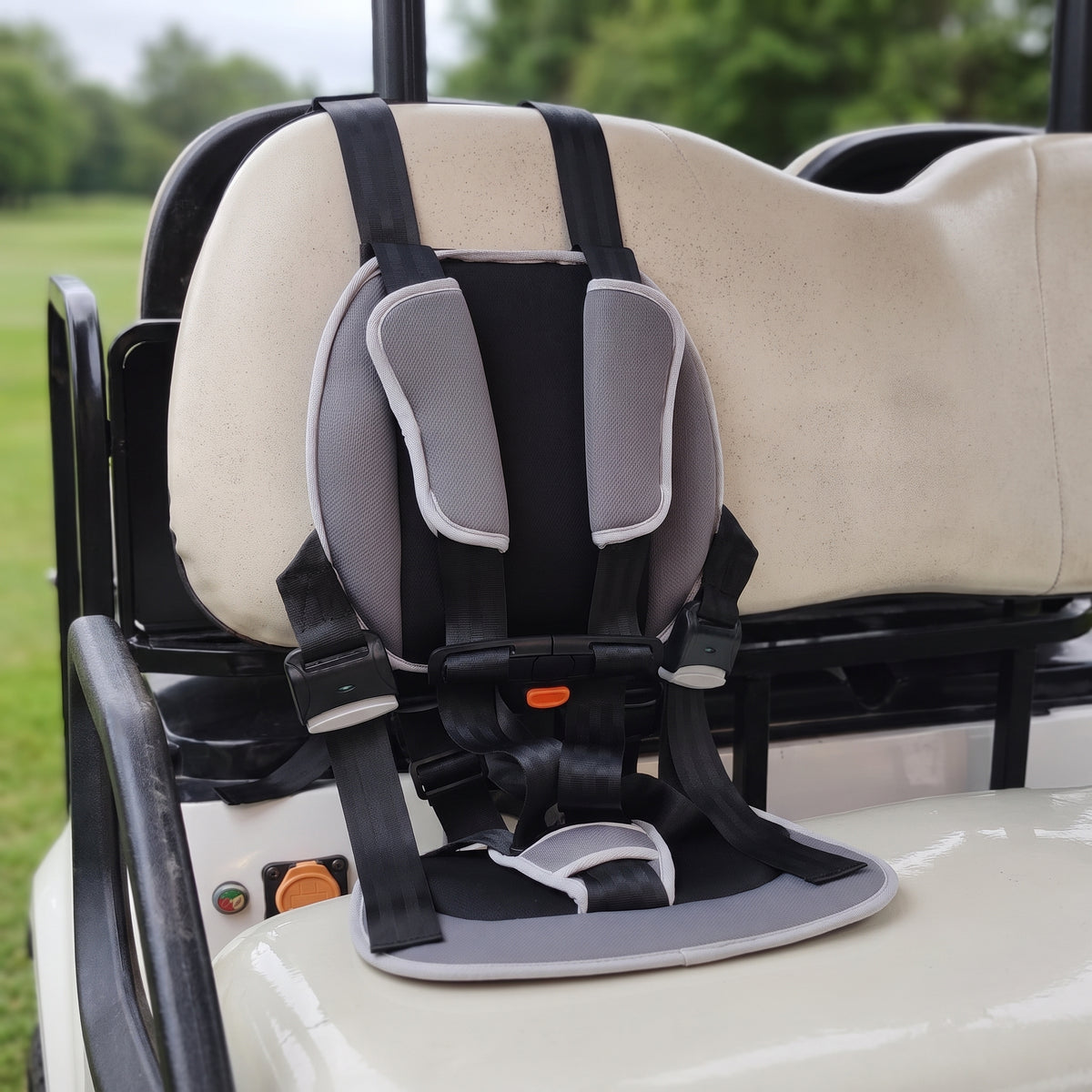 CubRide golf cart child harness installed on a cream bench seat